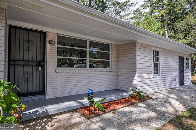 entrance to property with brick siding and visible vents