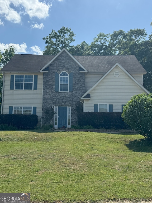 view of front of house with a front lawn and stone siding