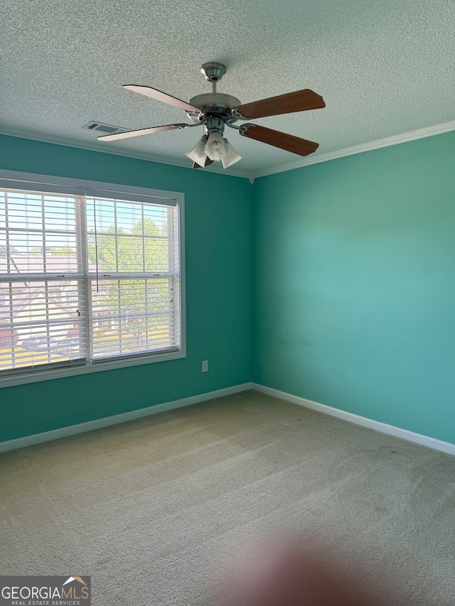 empty room featuring a textured ceiling, baseboards, ornamental molding, and carpet floors