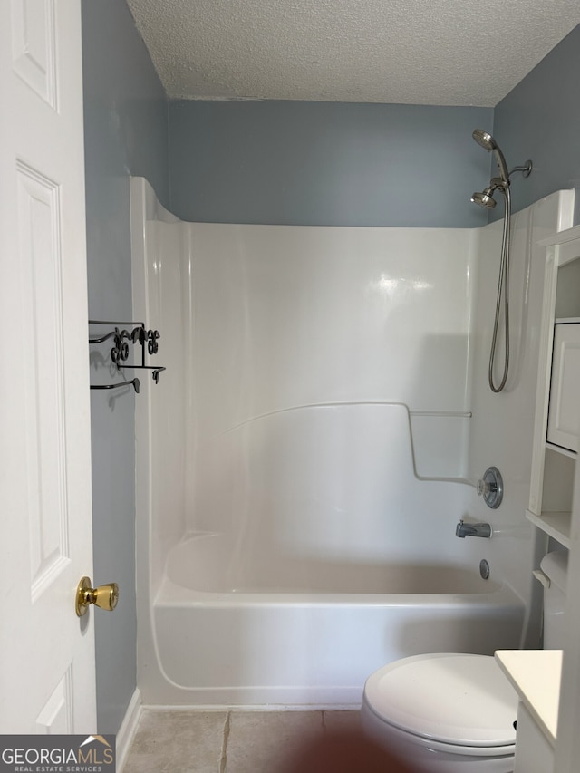 bathroom featuring toilet, tub / shower combination, tile patterned floors, a textured ceiling, and vanity