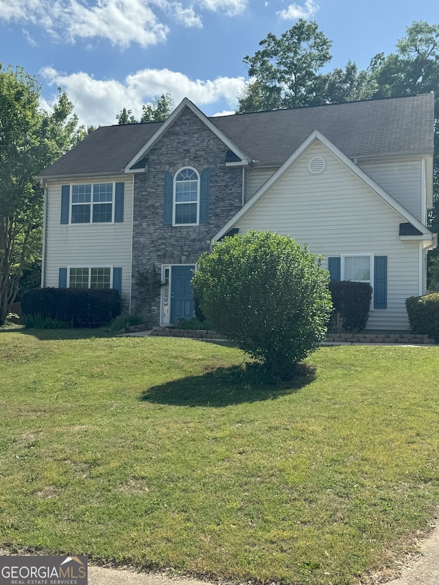 view of front facade featuring a front yard and stone siding