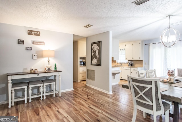 321 N Grove Blvd, Kingsland, GA 31548 - dining room with a chandelier, a textured ceiling, and wood finished floors