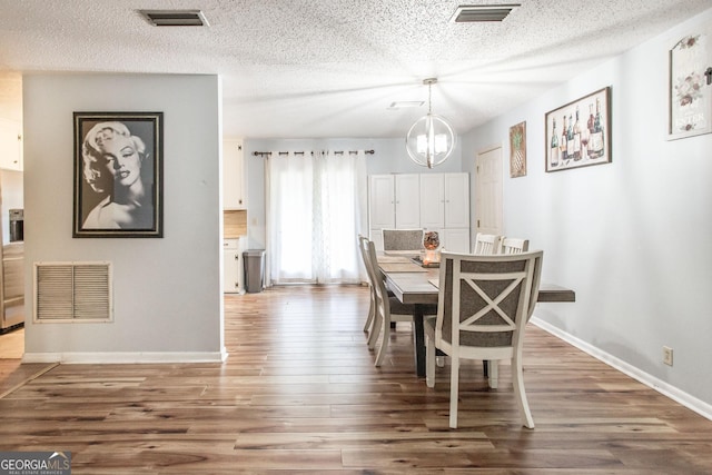 321 N Grove Blvd, Kingsland, GA 31548 - dining area featuring wood finished floors, a textured ceiling, and a chandelier