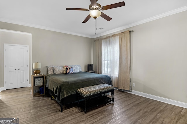 bedroom featuring baseboards, visible vents, wood finished floors, and crown molding
