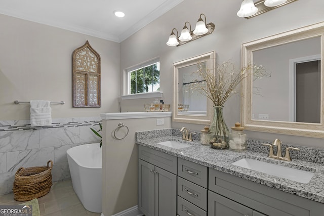 bathroom featuring double vanity, tile walls, a soaking tub, and a sink