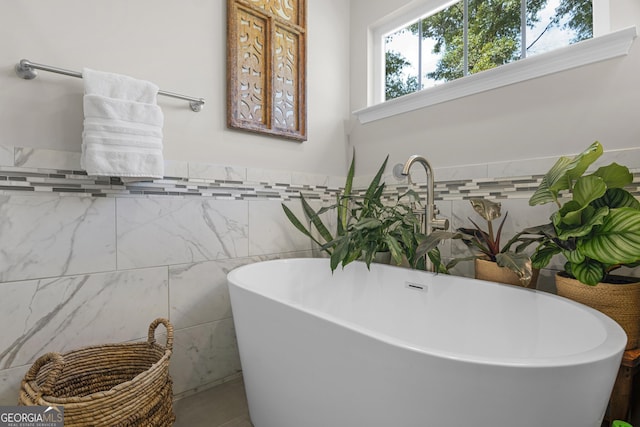 bathroom with a wainscoted wall, a freestanding bath, and tile walls