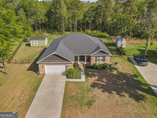 view of front of property featuring fence, concrete driveway, a front yard, and brick siding