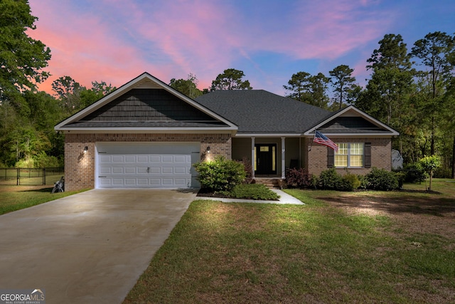 view of front of home with concrete driveway, fence, brick siding, a front lawn, and a garage