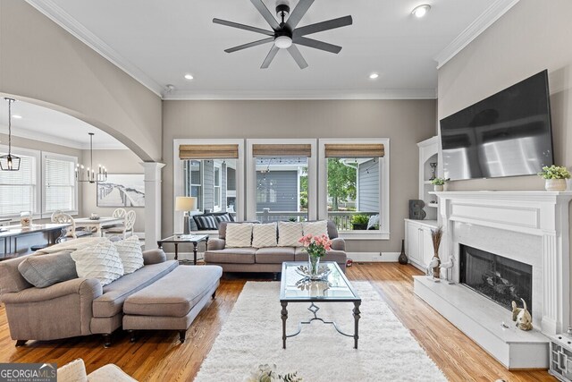 5841 Choctaw Ln, Braselton, GA 30517 - living room with wood finished floors, ceiling fan with notable chandelier, a high end fireplace, and arched walkways