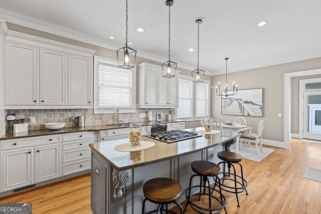 5841 Choctaw Ln, Braselton, GA 30517 - kitchen featuring a sink, decorative backsplash, a breakfast bar area, visible vents, and a kitchen island