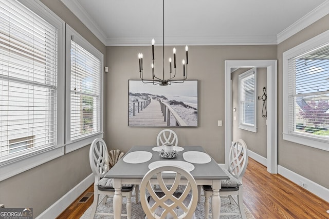 5841 Choctaw Ln, Braselton, GA 30517 - dining room with crown molding, a chandelier, visible vents, baseboards, and wood finished floors
