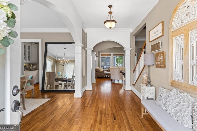 5841 Choctaw Ln, Braselton, GA 30517 - entryway featuring arched walkways, wood finished floors, baseboards, stairway, and crown molding