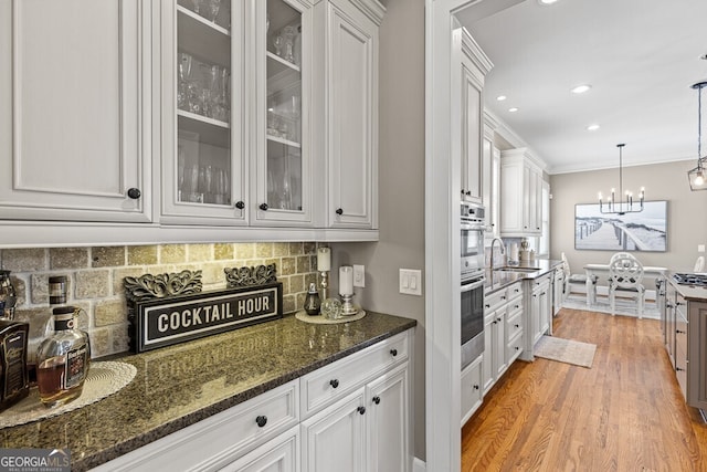 5841 Choctaw Ln, Braselton, GA 30517 - kitchen featuring white cabinetry, backsplash, a notable chandelier, and a sink