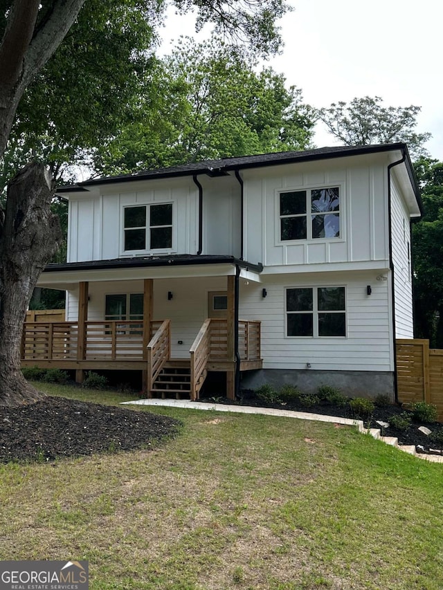 view of front of house featuring a porch, fence, board and batten siding, and a front yard