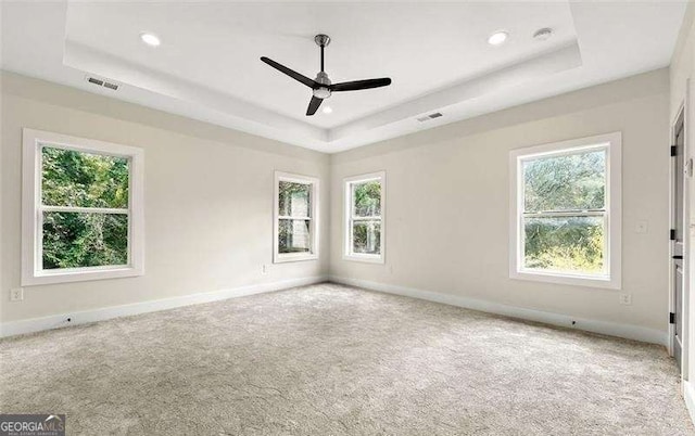 unfurnished room featuring baseboards, visible vents, and a raised ceiling
