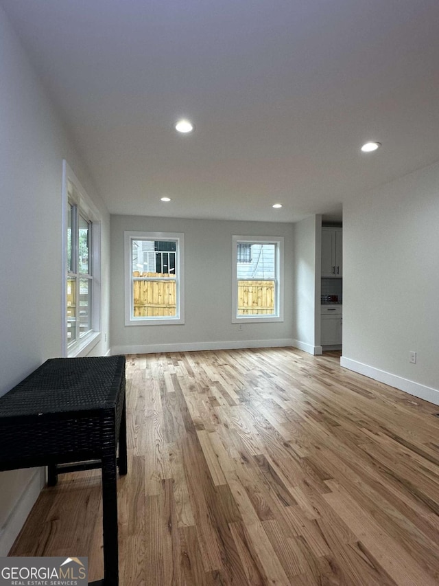 unfurnished living room featuring baseboards, light wood-type flooring, and recessed lighting