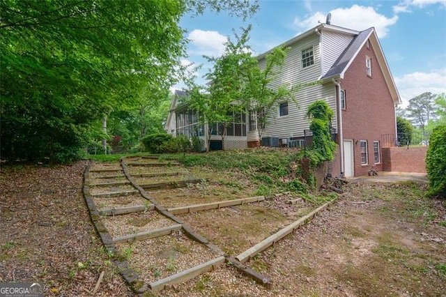 5208 Fox Hill Ct, Peachtree Corners, GA 30092 - rear view of house with a sunroom, a garden, and brick siding