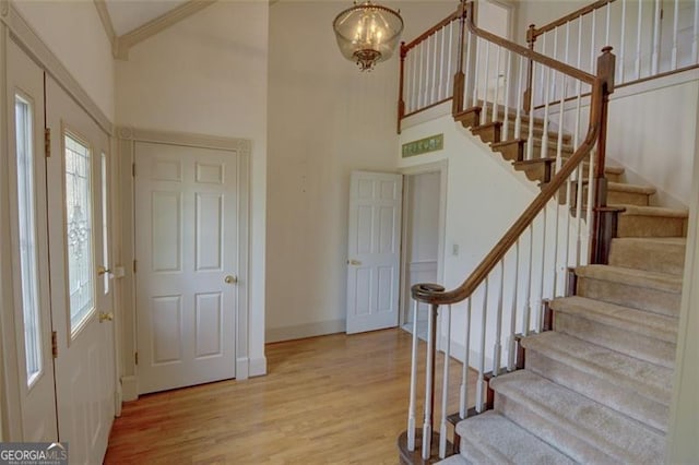 5208 Fox Hill Ct, Peachtree Corners, GA 30092 - foyer entrance with wood finished floors, stairs, a high ceiling, a chandelier, and ornamental molding