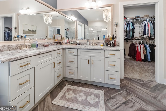 461 Preakness Way, Forsyth, GA 31029 - bathroom with double vanity, a shower stall, a walk in closet, and a chandelier