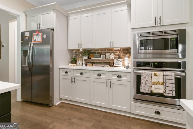 461 Preakness Way, Forsyth, GA 31029 - kitchen with stainless steel appliances, light countertops, decorative backsplash, white cabinetry, and wood finished floors