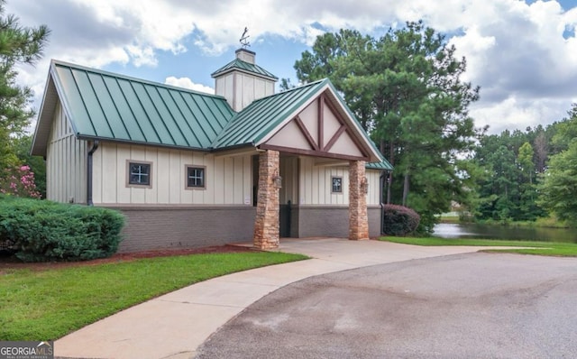 461 Preakness Way, Forsyth, GA 31029 - view of front of property featuring a front lawn, a chimney, a standing seam roof, board and batten siding, and metal roof
