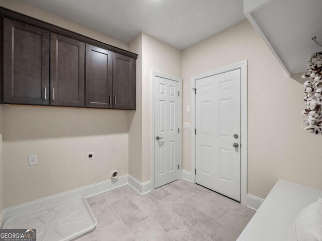 washroom featuring electric dryer hookup, cabinet space, and baseboards