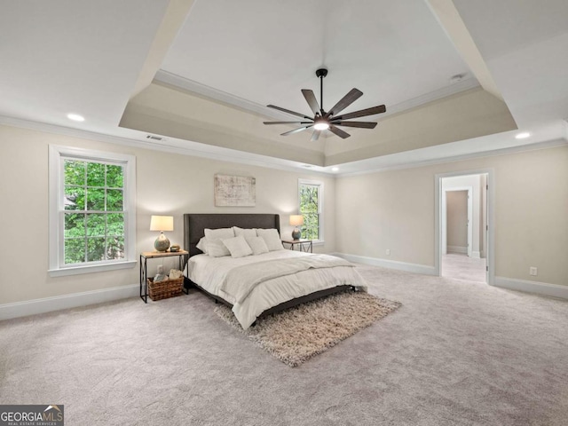 carpeted bedroom featuring ornamental molding, a raised ceiling, and baseboards