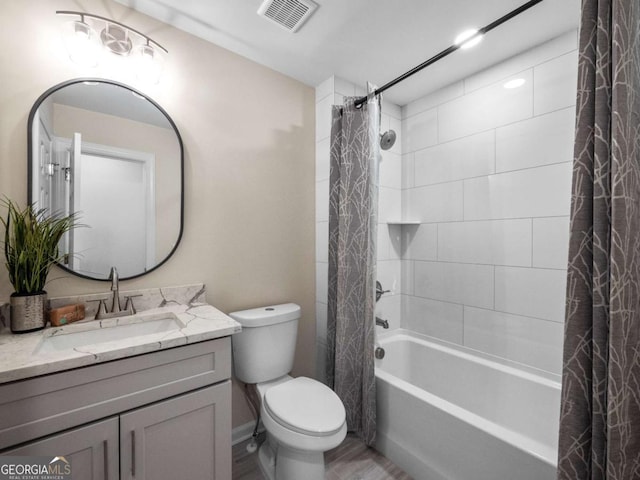 bathroom featuring visible vents, shower / bath combo with shower curtain, toilet, wood finished floors, and vanity