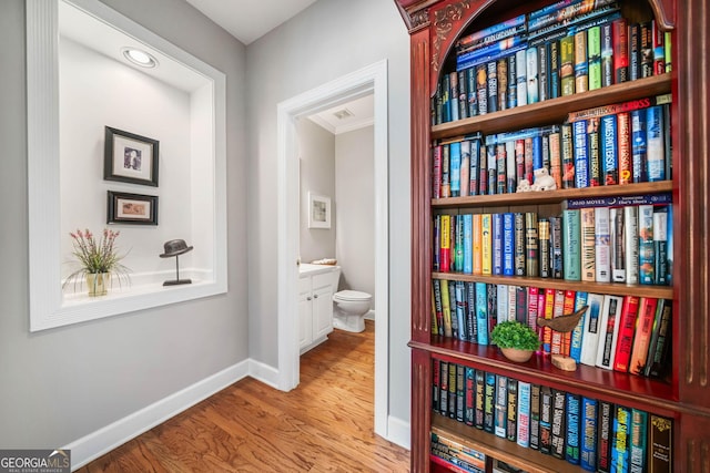 corridor featuring baseboards and wood finished floors