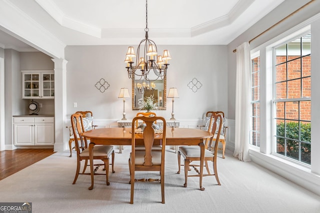 dining room featuring crown molding, an inviting chandelier, a healthy amount of sunlight, and a raised ceiling