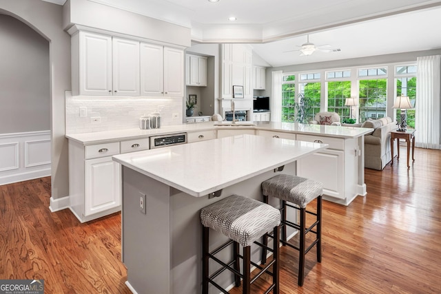 kitchen with a kitchen breakfast bar, a sink, light countertops, a peninsula, and open floor plan