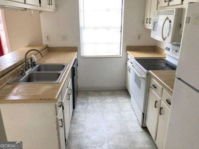 2617 Terrace Pkwy, Morrow, GA 30260 - kitchen featuring light countertops, a sink, white cabinets, and white appliances