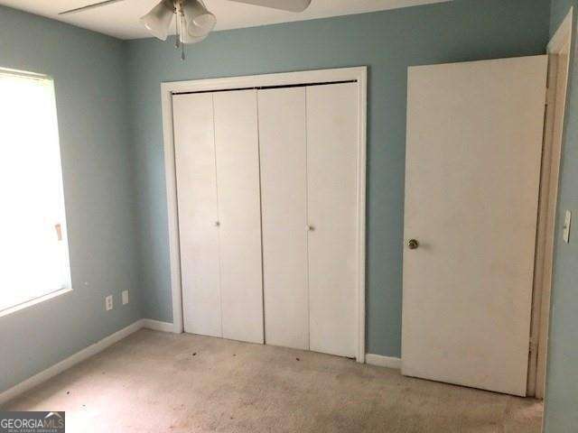 2617 Terrace Pkwy, Morrow, GA 30260 - unfurnished bedroom featuring a closet, a ceiling fan, light colored carpet, and baseboards