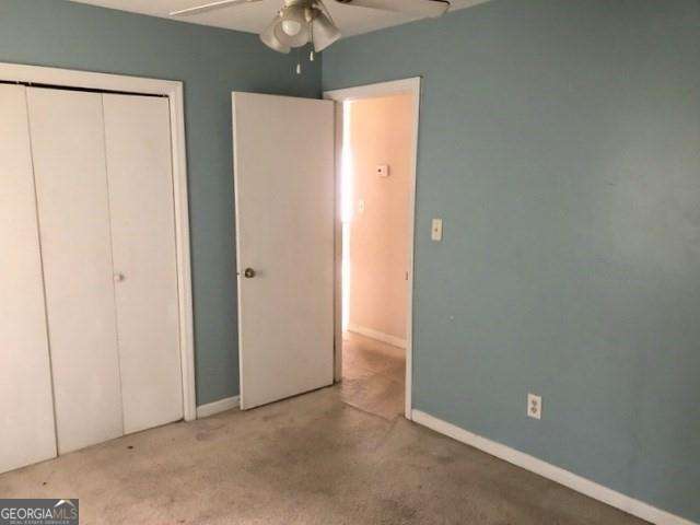 2617 Terrace Pkwy, Morrow, GA 30260 - unfurnished bedroom featuring a closet, a ceiling fan, carpet floors, and baseboards