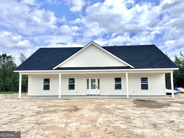 back of property featuring roof with shingles and a porch
