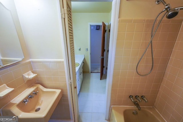full bathroom with a sink, wainscoting, bathing tub / shower combination, and tile patterned floors