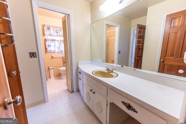 bathroom featuring toilet, tile patterned flooring, and vanity