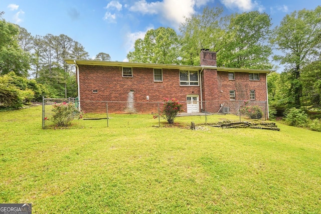 back of property featuring fence, a chimney, a yard, and brick siding