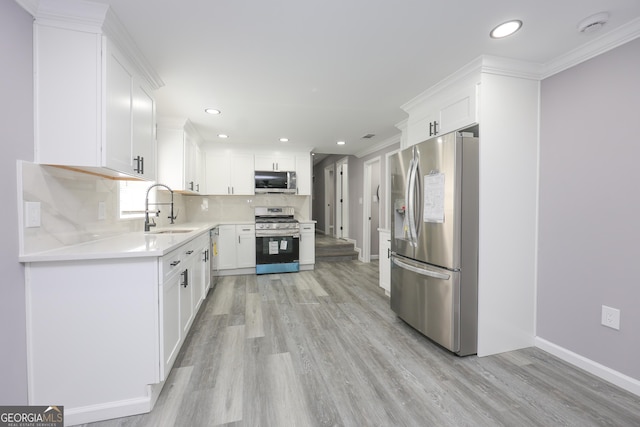 938 Motley St, Lagrange, GA 30241 - kitchen with light wood-style flooring, stainless steel appliances, light countertops, backsplash, and a sink