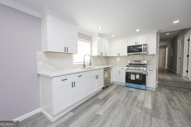 938 Motley St, Lagrange, GA 30241 - kitchen featuring a sink, stainless steel appliances, light wood-type flooring, backsplash, and light countertops