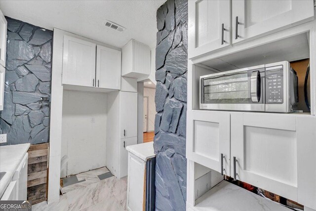 376 Mauldin Rd, Thomaston, GA 30286 - laundry area with marble finish floor, visible vents, and a textured ceiling