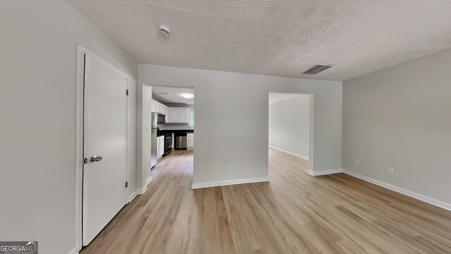 829 Longfellow Ct, Stone Mountain, GA 30088 - unfurnished room with baseboards, visible vents, a textured ceiling, and light wood finished floors