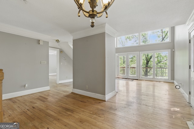 15635 US Highway 27 N, Hamilton, GA 31811 - unfurnished living room with baseboards, a chandelier, ornamental molding, and light wood-type flooring