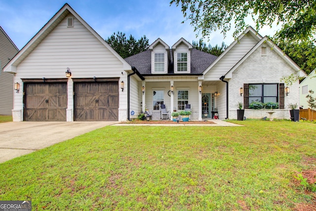 view of front of property featuring a porch, a front lawn, a garage, driveway, and a shingled roof