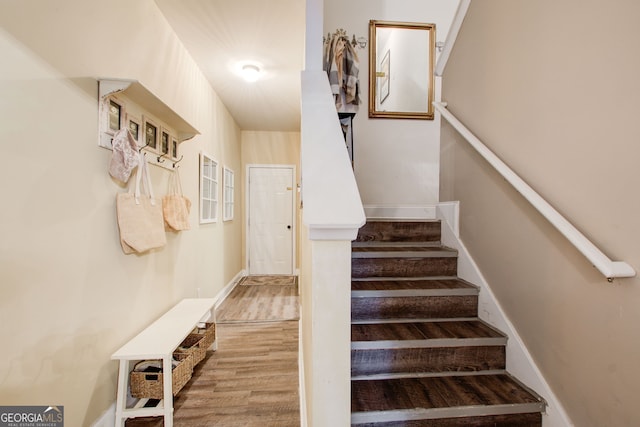 stairway featuring wood finished floors and baseboards