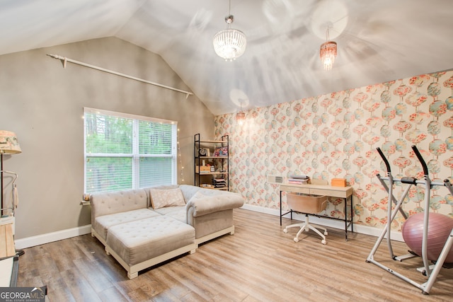 living area featuring vaulted ceiling, wood finished floors, and baseboards