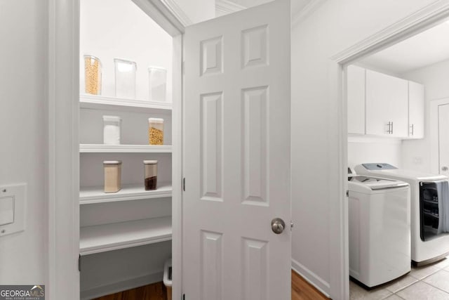 washroom with cabinet space and washer and clothes dryer