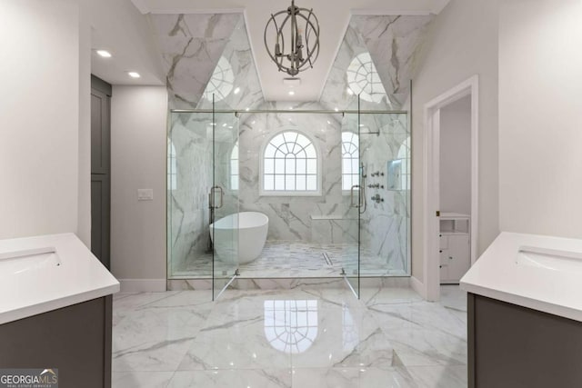 bathroom featuring a freestanding tub, a marble finish shower, two vanities, and marble finish floor