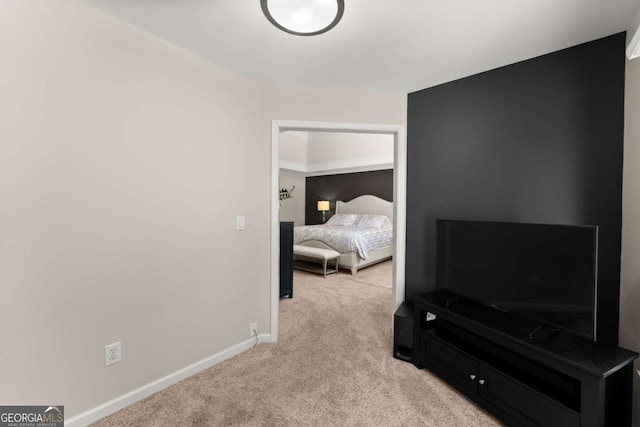 bedroom with baseboards and light colored carpet