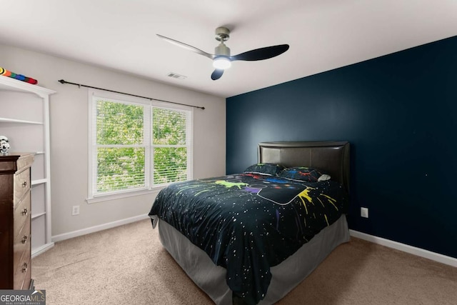carpeted bedroom featuring baseboards, a ceiling fan, and visible vents